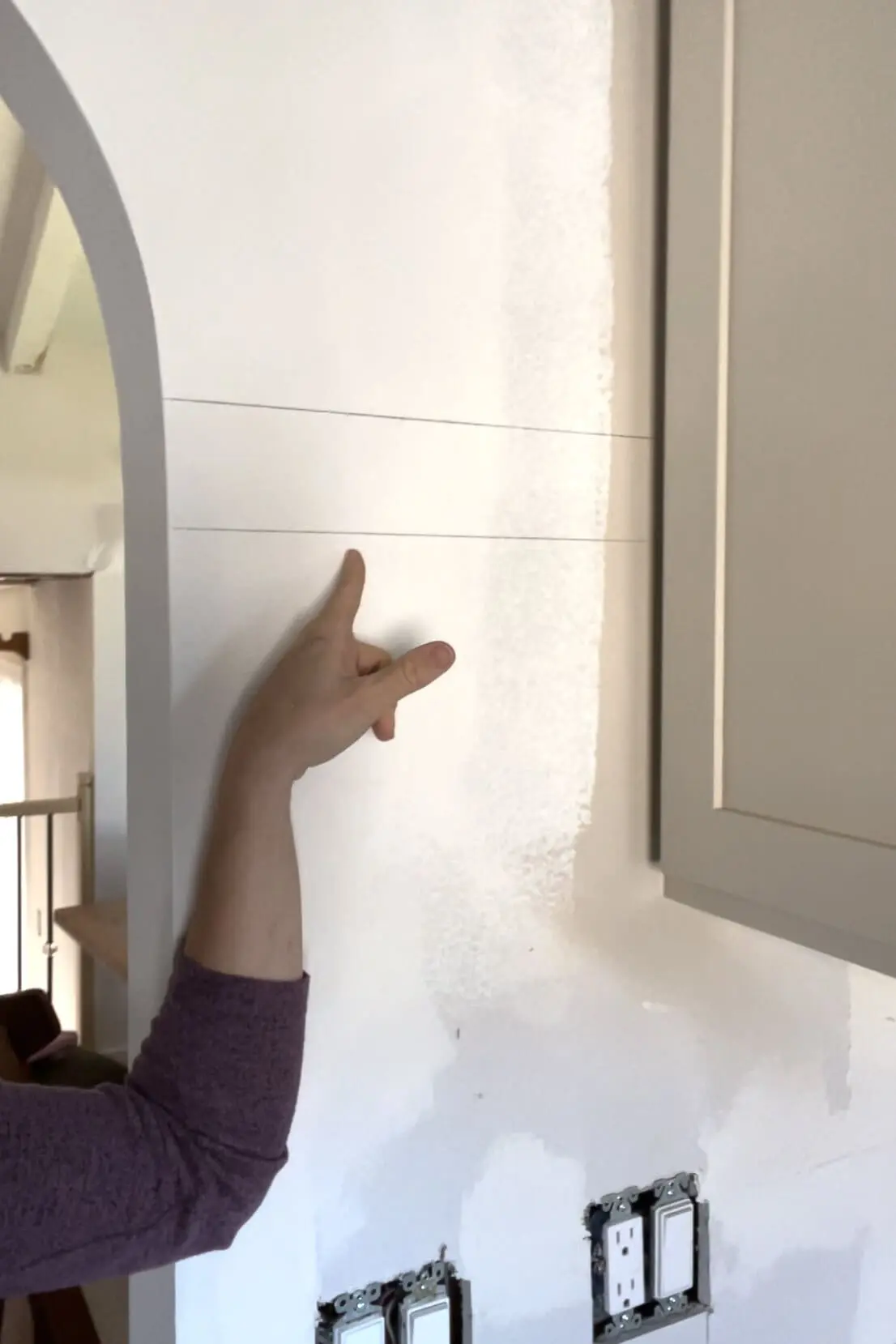 Installing a DIY shiplap backsplash.